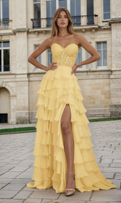 Woman wearing a yellow evening gown with a tiered ruffle a-line skirt in front of a building
