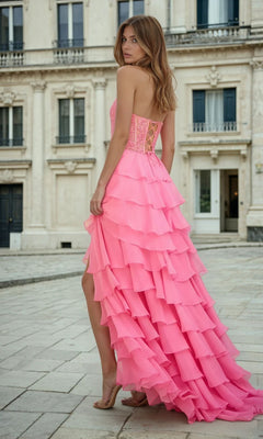 Woman in a pink ruffled floor-length dress standing in front of a classical building.