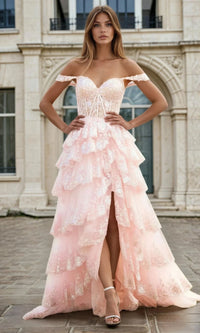Woman in a pink a-line tiered evening gown standing in front of an architectural building.
