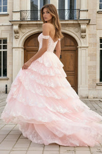 Woman modeling the back of a pink a-line dress standing in front of a building with wooden doors.