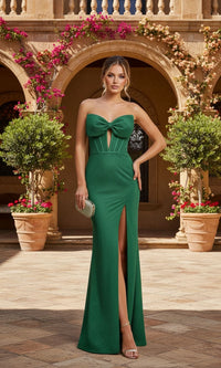 Woman in a green evening gown standing in front of an archway with floral decorations.