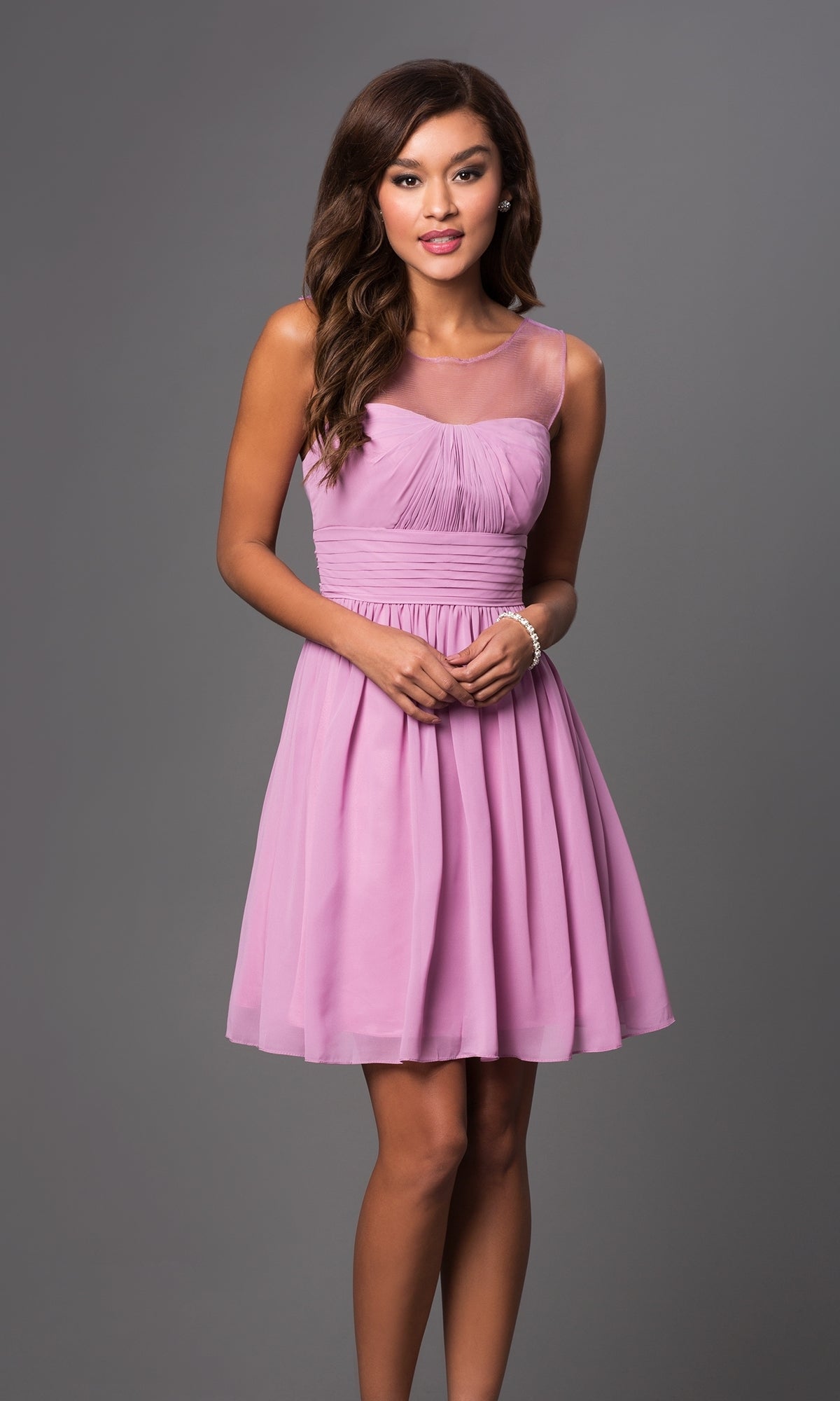 A woman models the Sheer-Neck Short Wedding-Guest Party Dress 7006, a sleeveless, knee-length light purple dress with a fitted bodice and flowing skirt, standing against a plain gray background.