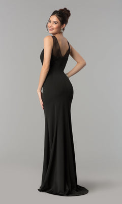 A woman smiles over her shoulder in the Illusion-Neckline Long Jersey Formal Prom Dress 8148, featuring sheer shoulder panels, against a gray backdrop.