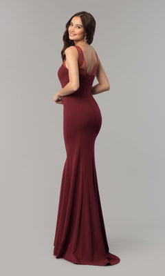A woman in the Illusion-Neckline Long Jersey Formal Prom Dress 8148—sleeveless, floor-length, and maroon with a low back—stands on a gray background, facing away and looking over her shoulder.