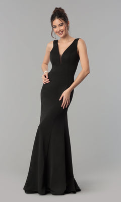 A woman stands and smiles in the Simple V-Neck Long Formal Jersey Prom Dress 8152 in black, featuring a sleeveless, floor-length design against a plain gray background.