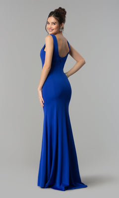 A woman poses with her back partly facing the camera, wearing the Simple V-Neck Long Formal Jersey Prom Dress 8152 in royal blue against a plain gray background.