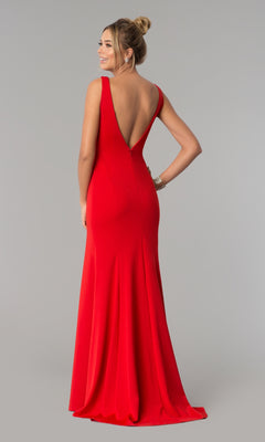 A woman models the Sleeveless V-Neck Long Formal Prom Dress 8158, featuring a deep V-back, as she stands facing away and looks over her shoulder against a plain gray background.