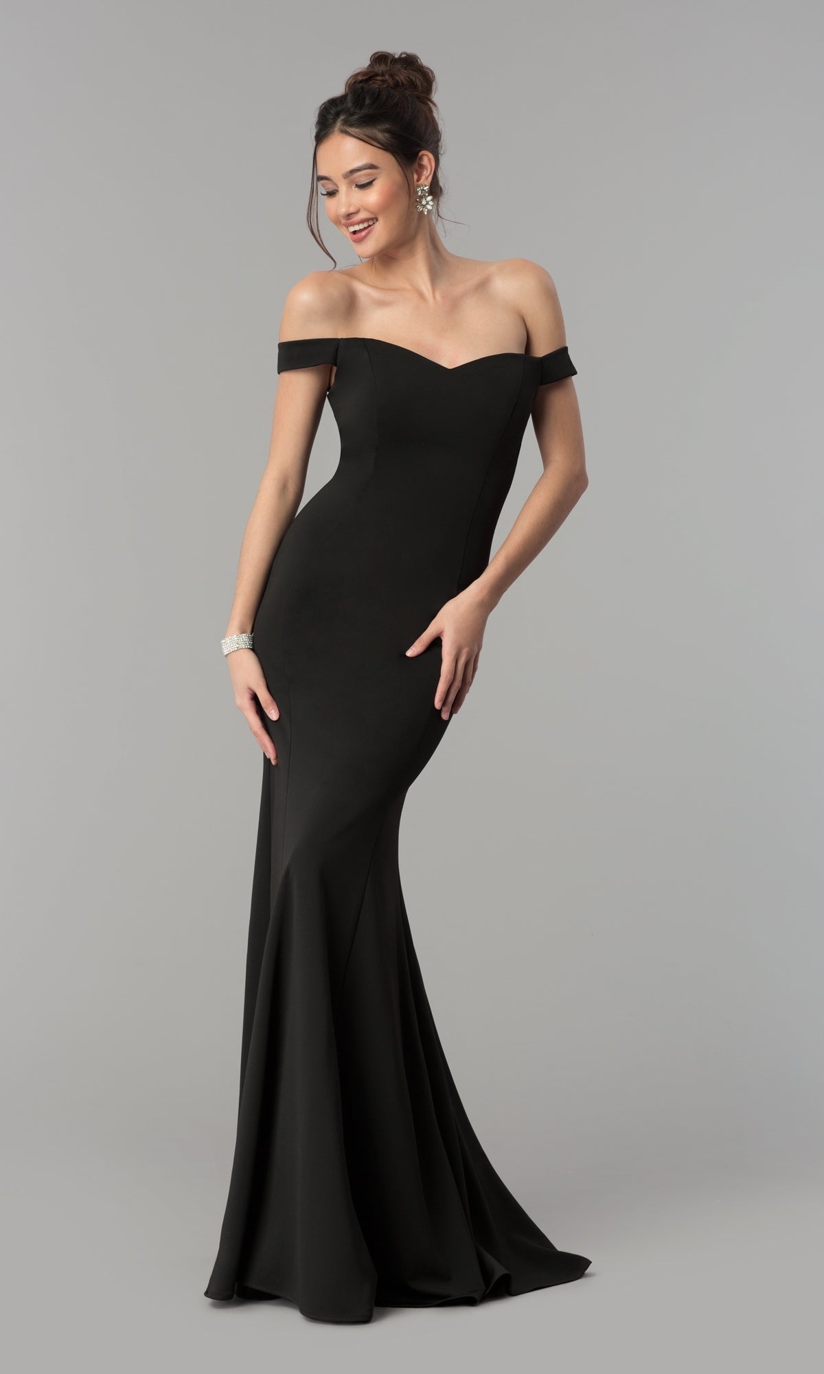 A woman poses gracefully against a plain grey background in the Simple Off-the-Shoulder Long Formal Prom Dress 8160, a fitted, floor-length gown in black.