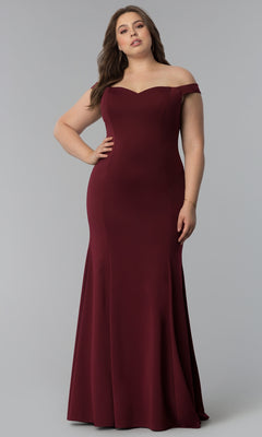A woman in the Simple Off-the-Shoulder Long Formal Prom Dress 8160, a fitted floor-length burgundy gown, stands against a plain gray background.