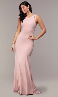 A woman poses against a grey background wearing the Strappy-Open-Back Long Formal Prom Dress 8232, a sleeveless, floor-length light pink gown with elegant open-back straps.
