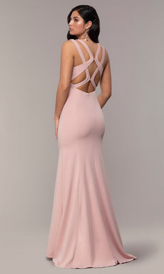 A woman wears the Strappy-Open-Back Long Formal Prom Dress 8232—a floor-length, pale pink gown with a fitted silhouette and a strappy open back featuring an elegant crisscross design.
