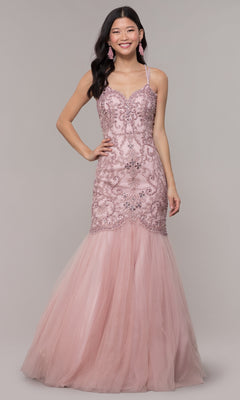 A woman in the Embroidered Tight Sweetheart Mermaid Prom Dress 8352, featuring light pink lace details and a tulle skirt, stands against a plain background, smiling at the camera.