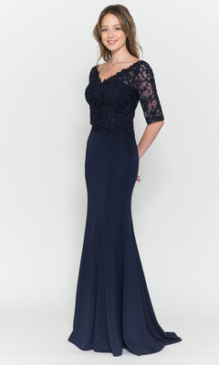 A woman poses against a plain white background in the Embroidered Sheer-Sleeved Formal Prom Dress 8560, a navy floor-length gown featuring lace detailing on the bodice and sheer sleeves.