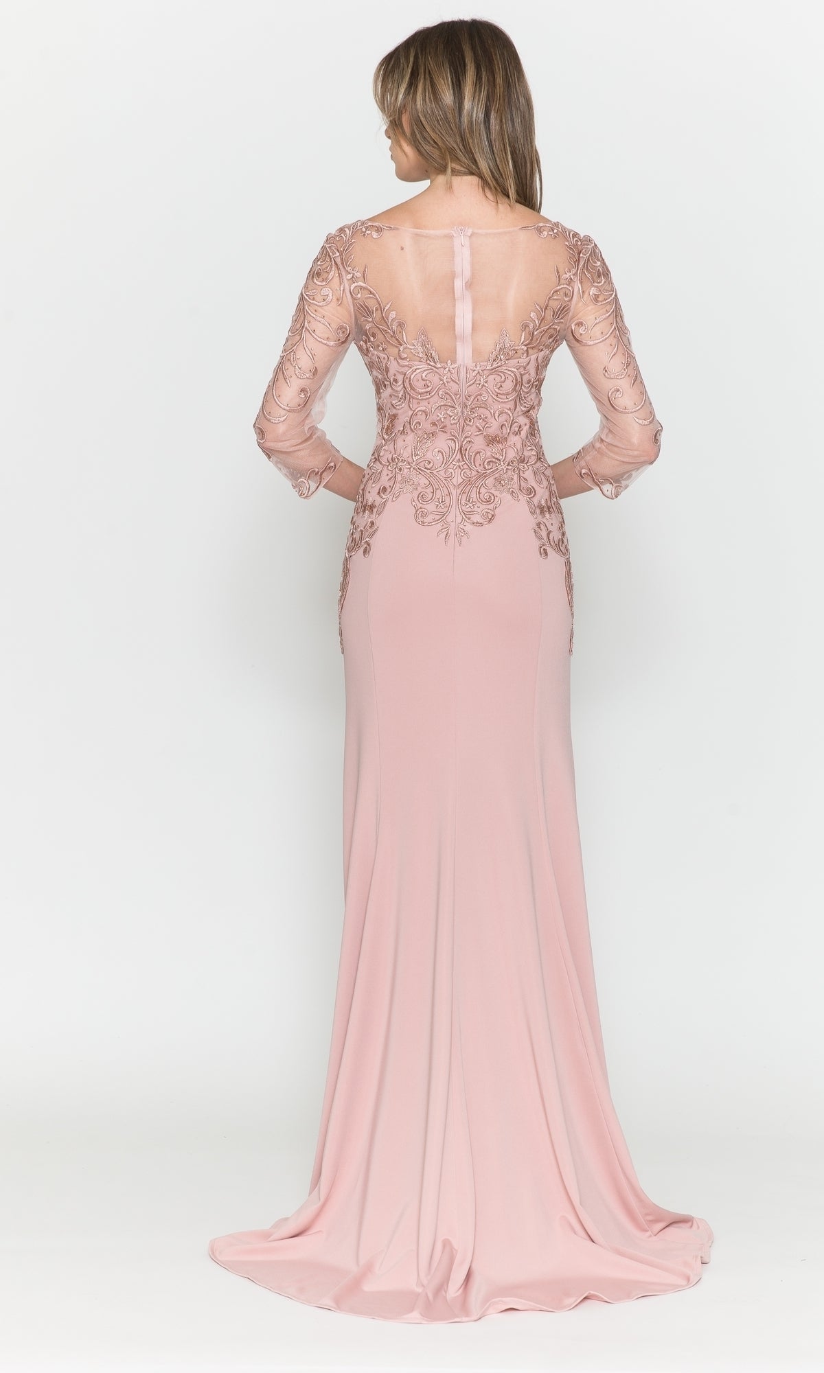 A woman models the Embroidered Sheer-Sleeved Long Prom Dress 8564, showcasing its sheer lace sleeves, embroidered details, and flowing floor-length skirt as she faces away.