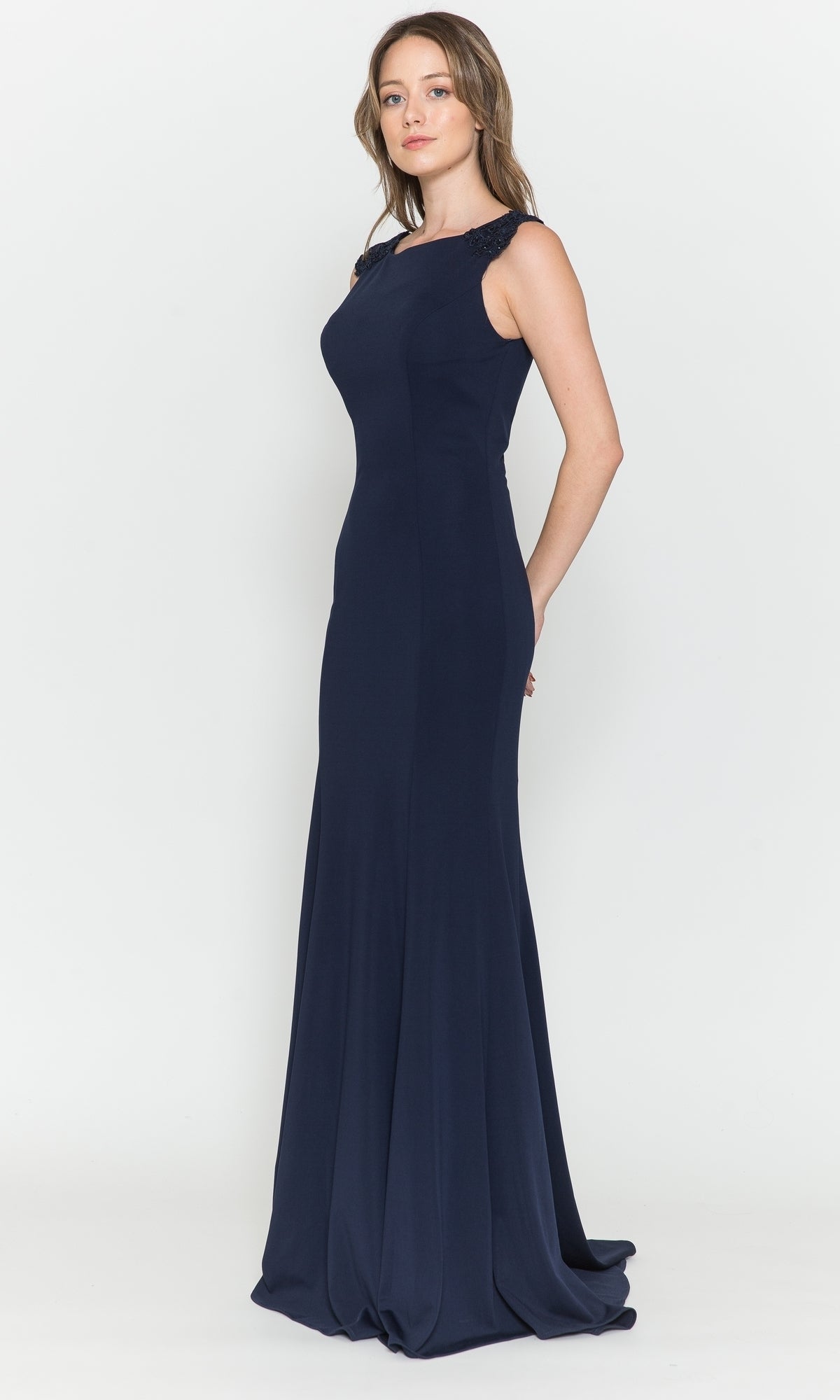A woman stands in profile against a white background wearing the High-Neck Simple Long Jersey Prom Dress 8566, a sleeveless, floor-length navy gown with a fitted bodice and flared skirt.