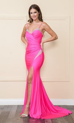 A woman stands indoors in the Faux-Wrap Long Stretch-Jersey Prom Dress 9042 in hot pink, featuring a thigh-high slit and sparkling strap details, posing with one hand on her hip.
