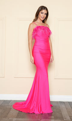 A woman stands against a beige wall with molding, wearing the Open-Back Long Feathered Prom Dress 9070—a vibrant pink, floor-length gown featuring feathered trim and detailed bodice accents.