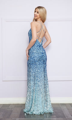 A woman models the Strappy-Back Long Sequin Ombre Prom Dress 9098, featuring blue ombré sequins and thin crisscross straps, as she poses sideways against a light purple paneled wall.