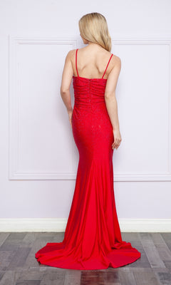 A woman with long blonde hair is seen from behind, wearing the Drape-Bodice Long Beaded Prom Dress: Poly USA 9130—a fitted, floor-length gown with thin straps—standing indoors against a light-colored wall.