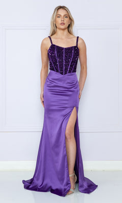 A woman in the Lace-Up Sequin-Bodice Long Satin Prom Dress 9176, featuring a sequin corset bodice, spaghetti straps, and a thigh-high slit satin skirt, stands against a light-colored wall.