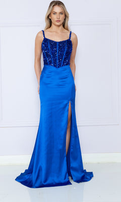 A woman in the Lace-Up Sequin-Bodice Long Satin Prom Dress 9176, featuring a sparkling bodice, thin straps, and a thigh-high slit, stands against a pale wall.