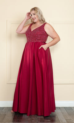 A woman smiles while touching her hair in the Beaded-Bodice Plus-Size Long Prom Dress W1066, a sleeveless, floor-length gown ideal for prom or any formal occasion.