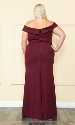 A person with long blonde hair is seen from behind wearing the Off-the-Shoulder Plus-Size Long Prom Dress W1118 in burgundy, standing indoors against a cream-colored wall.