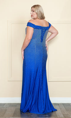 A woman in the Beaded Plus-Size Long Corset Prom Dress W1120 faces a beige wall, revealing the back details of her floor-length royal blue gown with sparkling rhinestone embellishments.