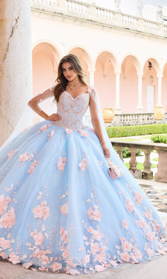 A woman in the PR22021 Princesa Glow-in-the-Dark Quinceañera Dress with pink floral details poses in a courtyard with arches and columns, holding a small handbag—a magical look inspired by Ariana Vara’s collection.