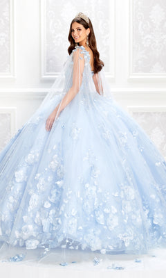 A woman in a light blue PR22021 Princesa Glow-in-the-Dark Quinceañera Dress with 3D floral accents and a sheer cape poses in an ornate white room.