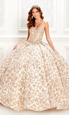A woman models the Strapless Quinceanera Dress: Princesa PR22022 in gold and white, featuring a full skirt, tiara, and statement necklace as she poses against an ornate white background.