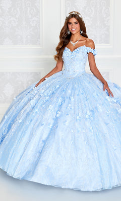 A young woman stands indoors wearing the Flower Quince Dress: Princesa by Ariana Vara PR22036, a light blue off-the-shoulder ball gown with floral details and a full skirt, paired with a tiara and necklace.