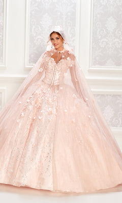 A woman in a light pink Flower Quince Dress: Princesa by Ariana Vara PR22036, featuring embellishments and a matching hooded cape, stands before a white patterned wall.