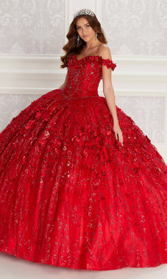 A woman in the Flower Quince Dress, Princesa by Ariana Vara PR22036, featuring a jeweled tiara and elaborate off-the-shoulder red gown with intricate embroidery, stands against a white ornate wall.