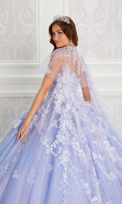 A young woman wearing the Quinceanera Dress PR22143 By Princesa, featuring a sparkly lavender hue, beaded corset bodice, floral lace details, and a tiara, poses before a patterned wallpaper backdrop.