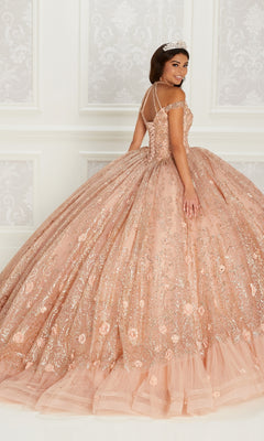 A woman in the Quinceanera Dress PR22144 By Princesa, featuring peach-colored glitter, intricate beading, and embroidery stands in an elegant room, wearing a tiara and looking over her shoulder.