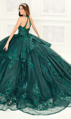 A woman wearing the Quinceanera Dress PR30082 By Princesa, featuring green embroidery with lace and sequin details, stands in a white room, smiling over her shoulder.