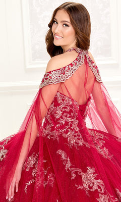 A young woman smiles as she poses with her back partly turned, wearing the Quinceanera Dress PR30086 by Princesa—a red, embroidered lace gown featuring sheer, beaded shoulder details.