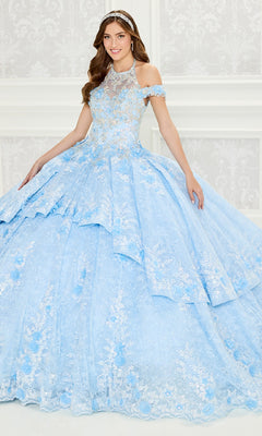 A young woman wears the Quinceanera Dress PR30089 By Princesa, a light blue embroidered lace ball gown with off-the-shoulder sleeves and a jeweled tiara, standing against a white patterned background.