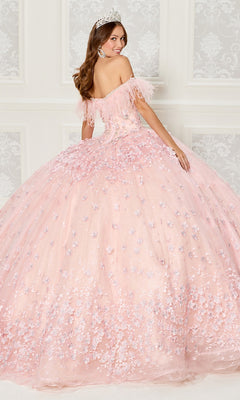 A woman in the Quinceanera Dress PR30115 By Princesa, featuring pink off-the-shoulder floral details and a tiara, stands before an ornate white wall, gazing over her shoulder.