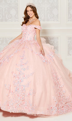 A young woman in the Quinceanera Dress PR30116 By Princesa, featuring pink off-the-shoulder floral details, a tiara, and necklace, stands before an ornate white wall.
