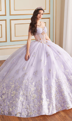 A young woman in the Quinceanera Dress PR30154 By Princesa, a lavender corset gown with gold floral embroidery and a tiara, stands in an elegant room with decorative wall paneling.