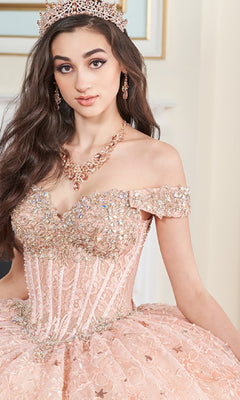 A young woman wears the Quinceanera Dress PR30177 By Princesa, an off-the-shoulder pink ball gown featuring a jeweled tiara, corset bodice, and embellished with lace and sequins.