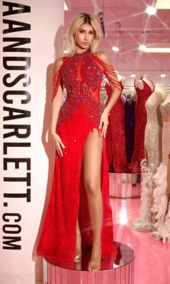 A woman wearing the red Long Prom Dress PS23704C by Portia and Scarlett stands in a store beside mannequins dressed in similar sheer illusion gowns.