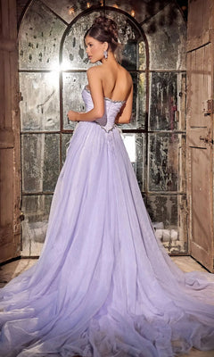 A woman in the Long Prom Dress PS24632 by Portia and Scarlett, a strapless A-line tulle ball gown with a beaded sweetheart neckline, stands with her back to the camera before large rustic windows.