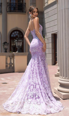 A woman stands outdoors in front of a building, wearing the Portia and Scarlett PS25234 long prom dress with lace beaded embellishments, flared train, and thin straps, looking over her shoulder.