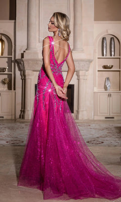 A woman in the Portia and Scarlett PS25289 long prom dress, a sparkly bright pink mermaid gown, stands with her back to the camera in an elegant room with shelves and decor.
