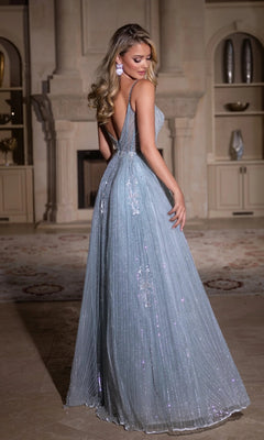 A woman wearing the Portia and Scarlett PS25310 long prom dress, a light blue beaded, floor-length gown with a low back, stands indoors and looks over her shoulder.