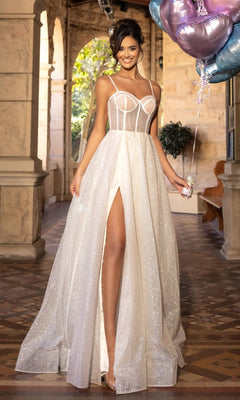 A woman in an ivory Portia and Scarlett PS25312 long prom dress with a sheer corset bodice and high slit stands indoors, holding balloons and smiling.