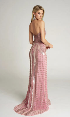 A woman wears the Portia and Scarlett PS25986C long formal dress—strapless, floor-length, fitted, and embellished with pink sequins—stands facing away, looking over her shoulder against a plain light background.